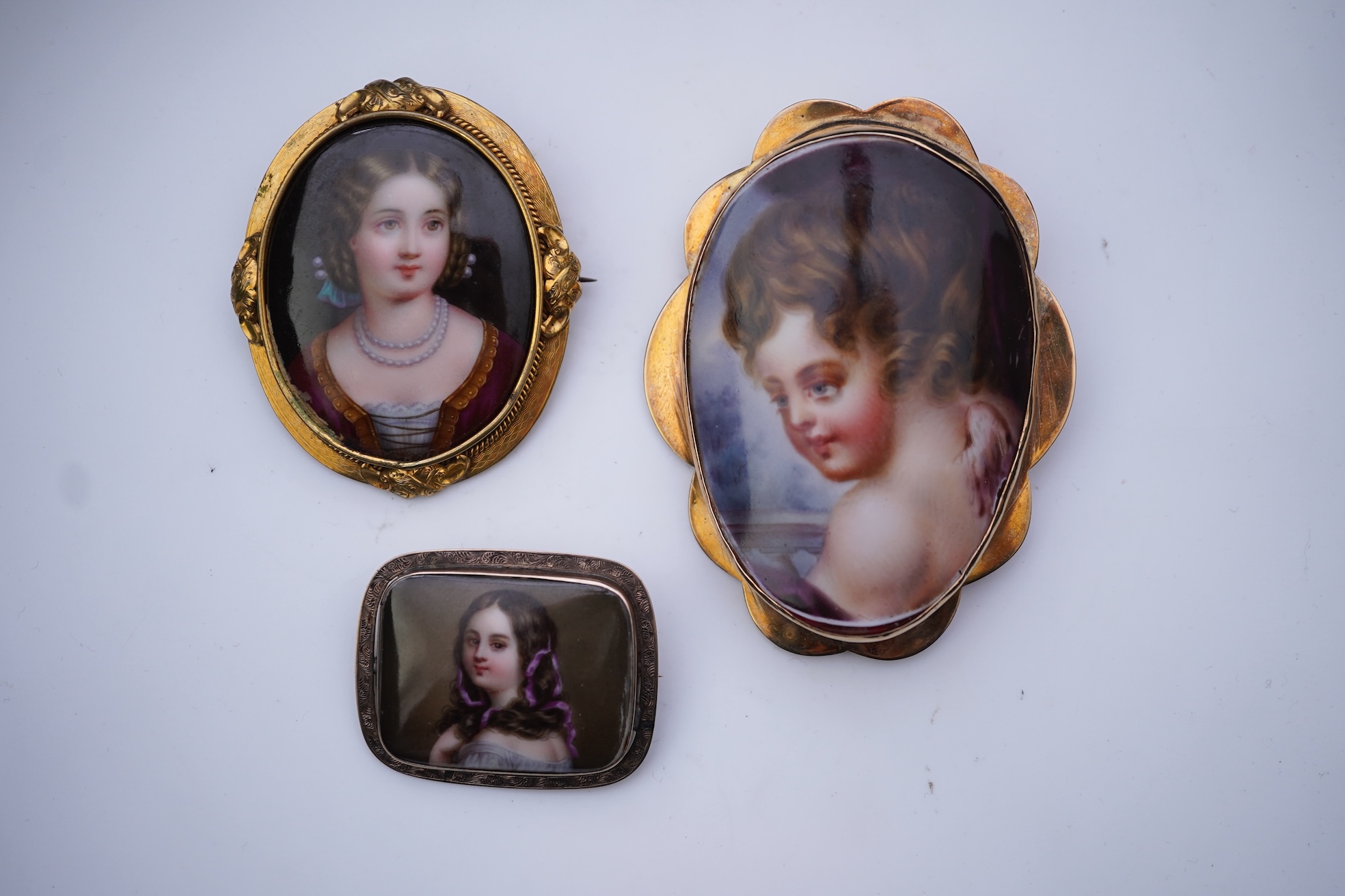 Three painted enamel brooches, mid 19th century